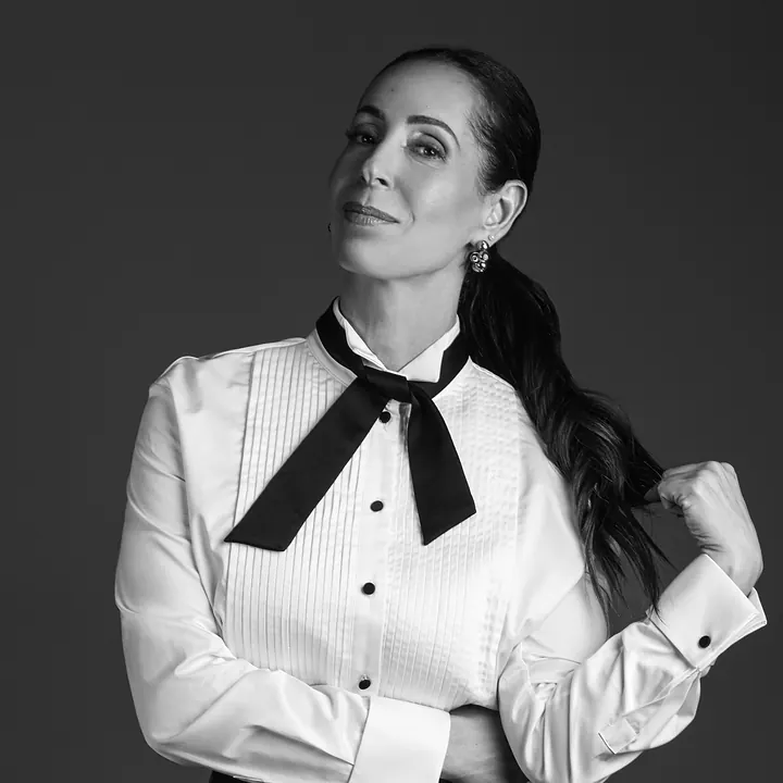 Dra. Denise de Carvalho de camisa branca e laço preto, em foto de estúdio em preto e branco